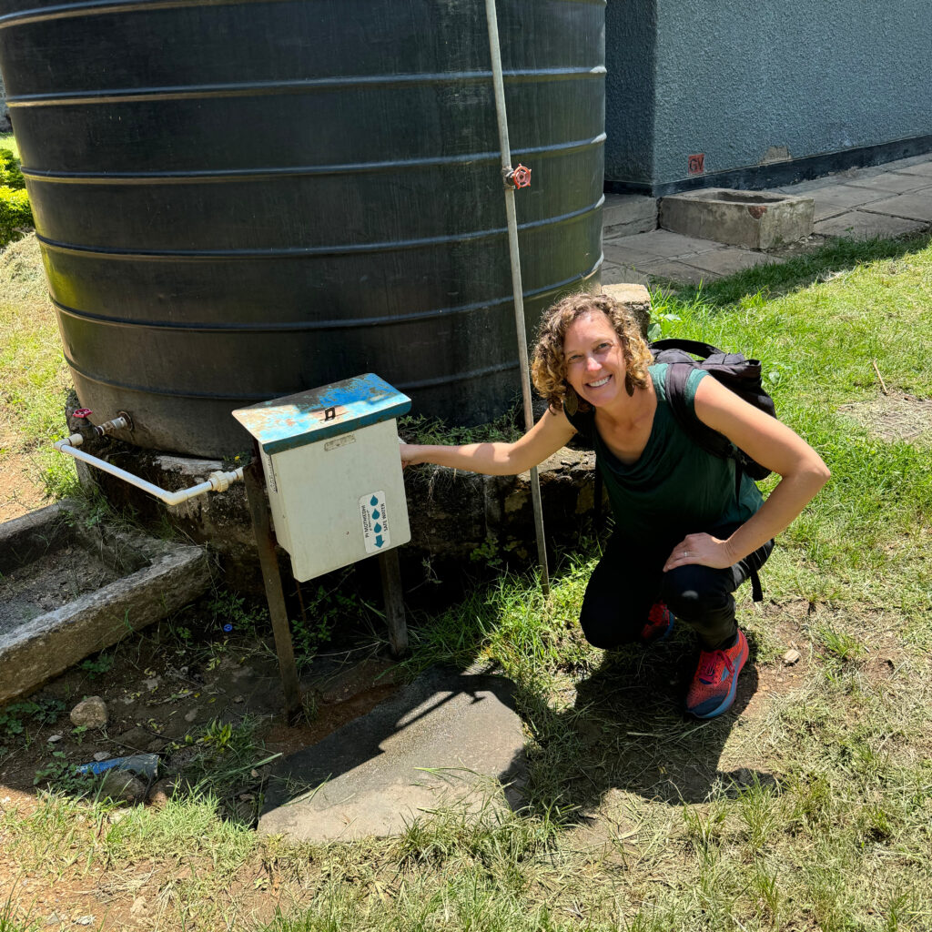 Pickering, kneeling, tests the TuriTap at a health care facility in Kenya.