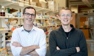 Neil King and David Veesler, standing in a lab and smiling at the camera.