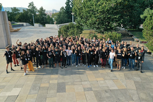 A large group of people gathered for a photo, many of them in a fist-pumping pose