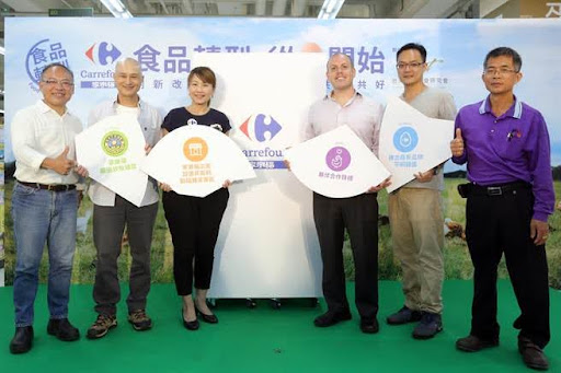 Six people smiling at the camera, at a conference booth in Taiwan