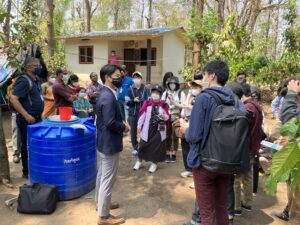 A well-dressed man answers questions from trip participants. The man is wearing a mask.